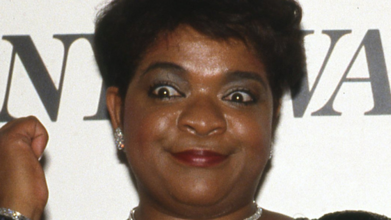 Nell Carter widens her eyes and points to her wrist