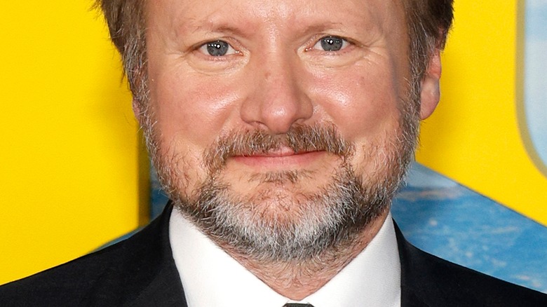 Rian Johnson smiles in suit
