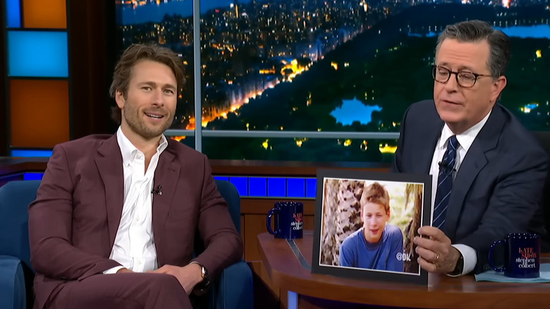 Stephen Colbert shows Glen Powell a picture of him on Endurance