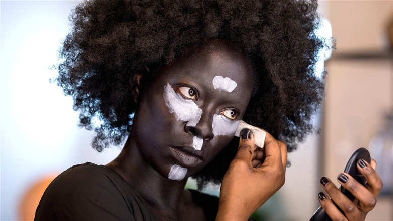 Woman putting makeup on her face