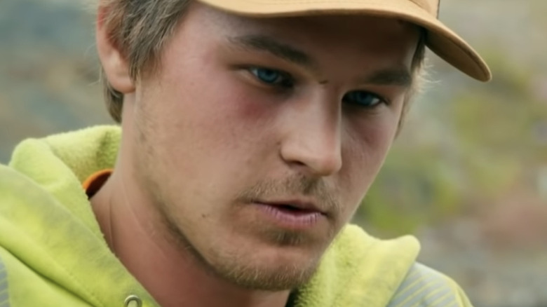 One of the clayton brothers staring down at a pot of gold