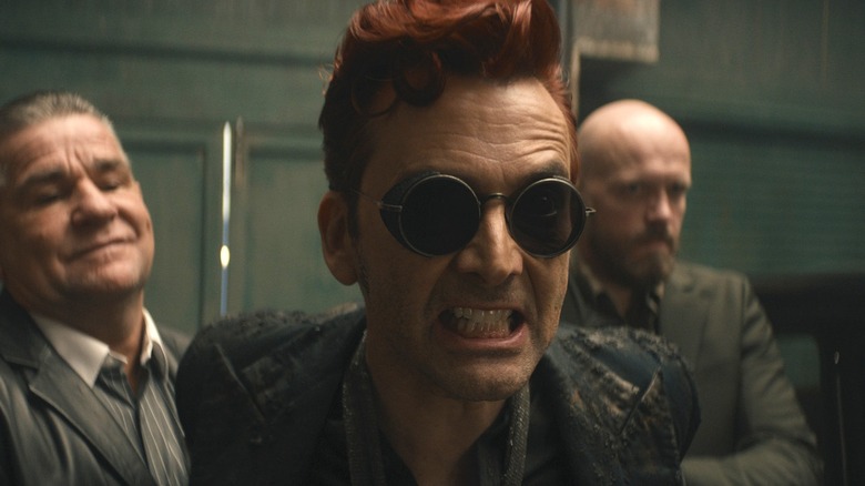 Crowley snarling his teeth between gangsters in 