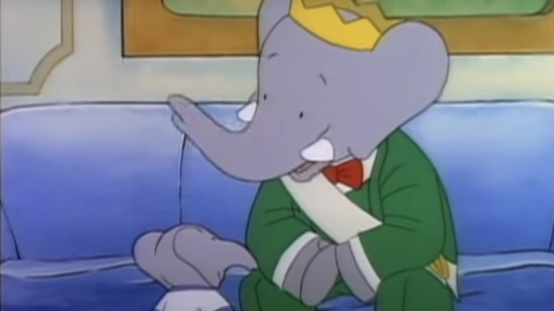 Babar the Elephant speaking to a smaller elephant while sitting on a couch 