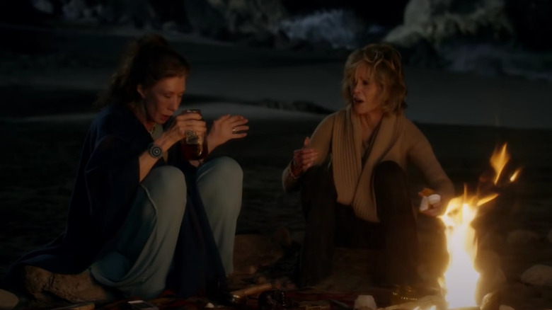 Grace and Frankie by a campfire