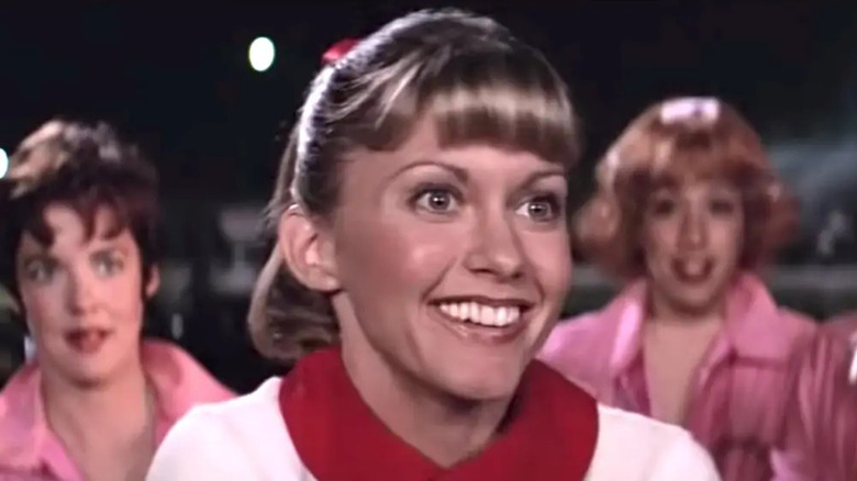 Sandy smiles excitedly in close-up