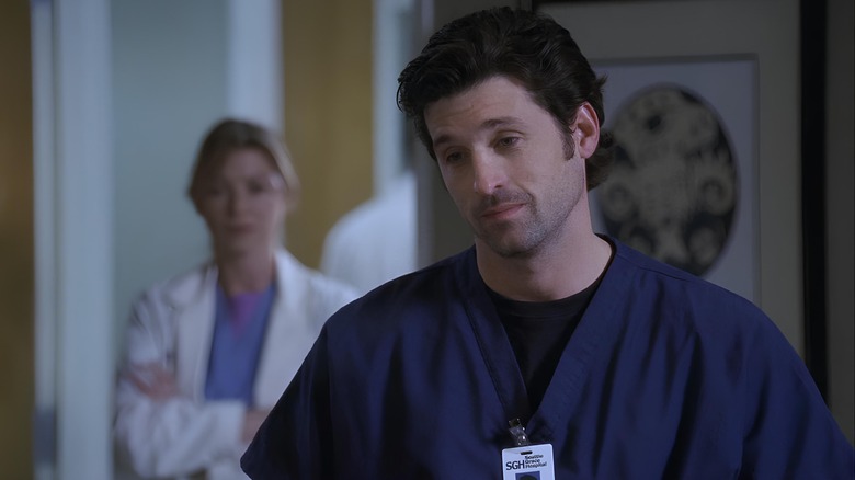 Derek looking down with Meredith standing behind him