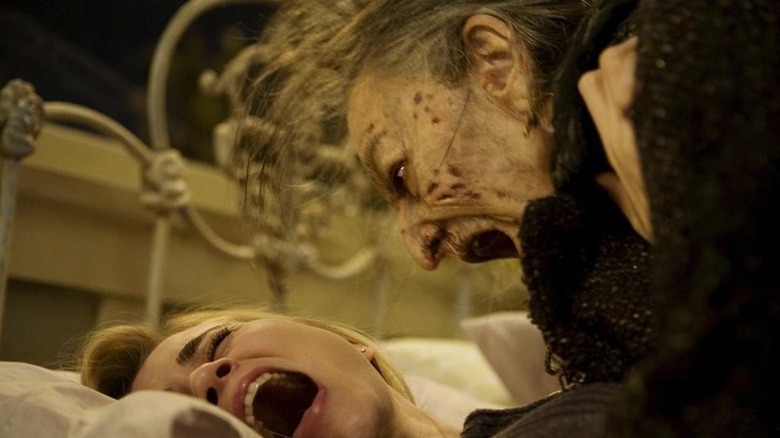 A demonic woman screams over Christine in bed in "Drag Me To Hell" (2009)
