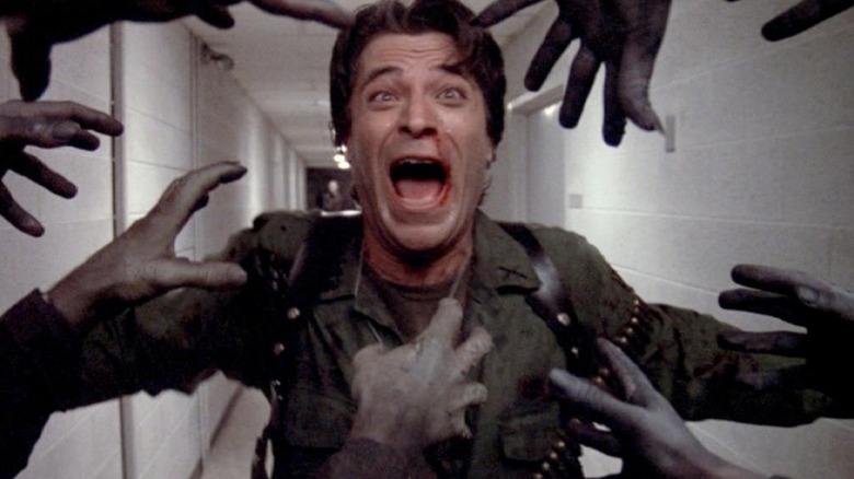 Captain Rhodes screams as zombie hands grab him in "Day of the Dead" (1985)
