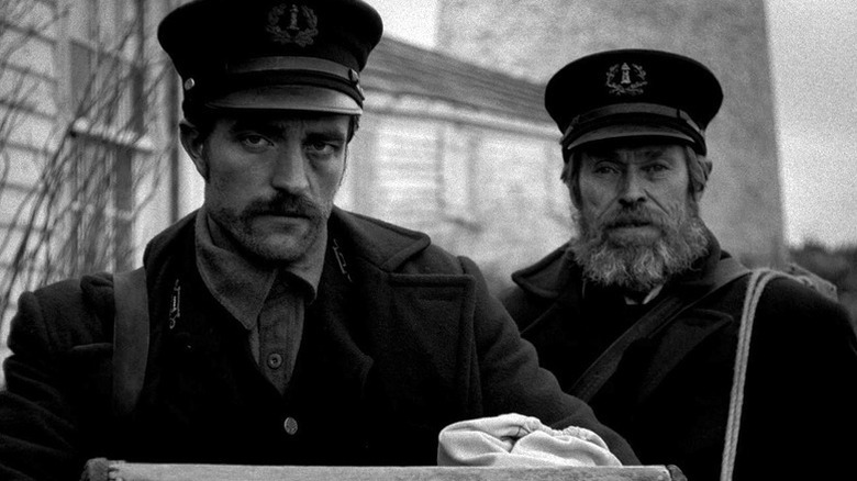 Ephraim and Thomas stand by the lighthouse in "The Lighthouse" (2019)