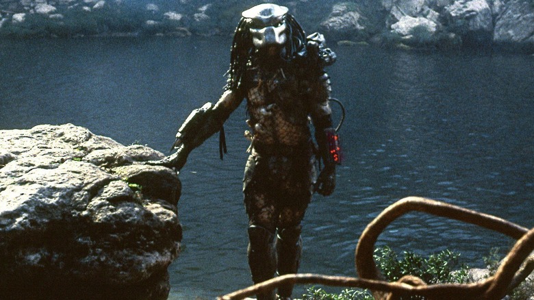 The Predator standing around near a lake in Predator (1987)