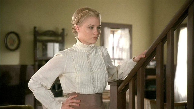 A dubious Belinda standing next to set of stairs in Love Finds a Home (2009)