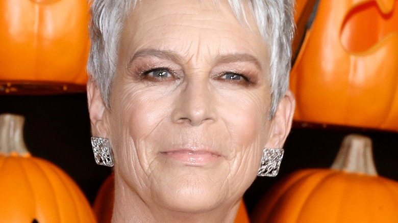 Jamie Lee Curtis posing by pumpkins