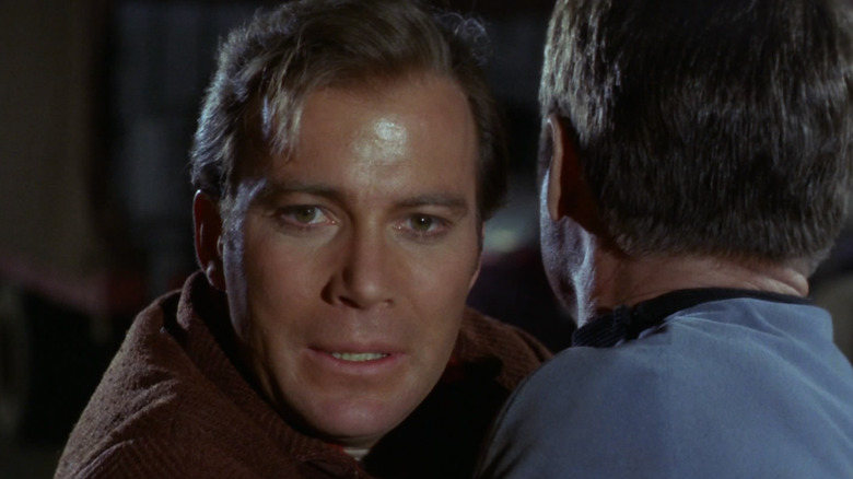 Captain Kirk looking sad hugging Leonard McCoy in Star Trek