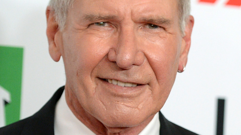 Harrison Ford grinning against a white backdrop