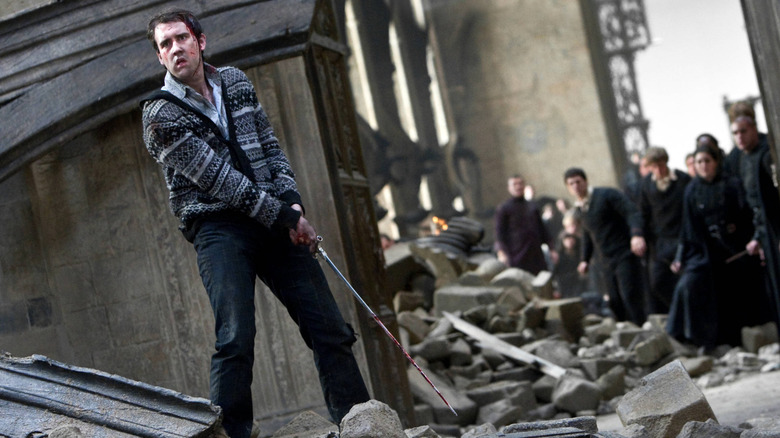Neville holding sword in rubble