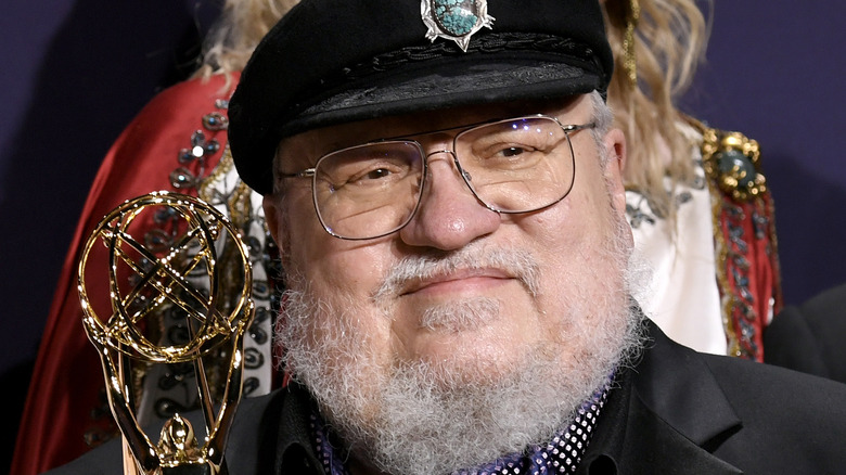 George RR Martin holding an Emmy Award