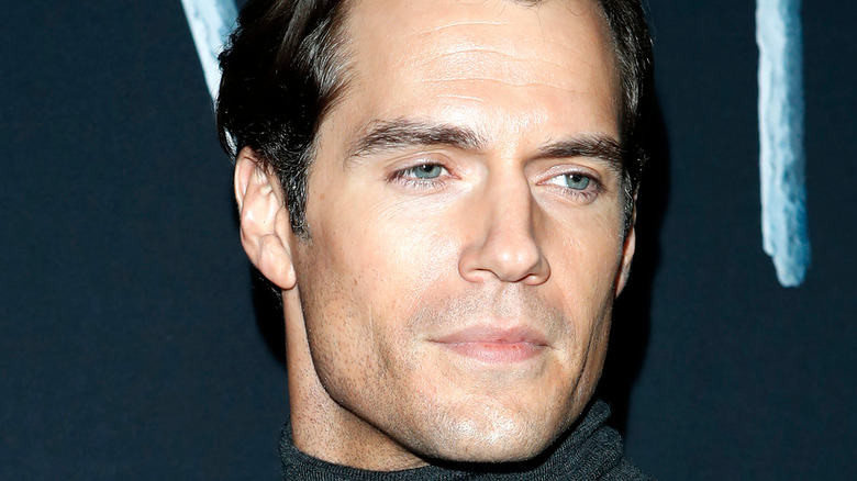 Henry Cavill looks stoic and over his shoulder at the Witcher premier