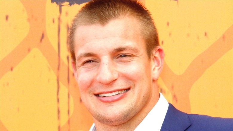 Rob Gronkowski smiling yellow background