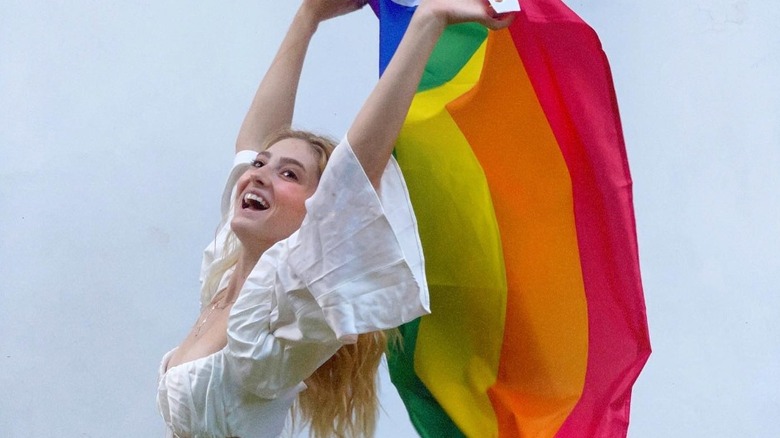 Willow holding a rainbow flag