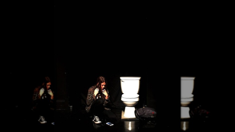 A girl on the floor with a toilet