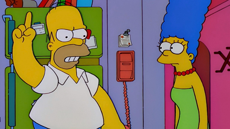 Homer Simpson waving finger at Marge Simpson