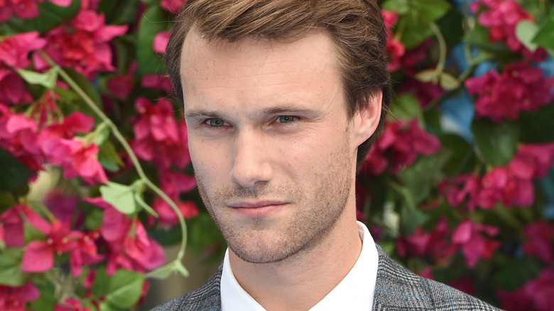 Hugh Skinner in front of flowers
