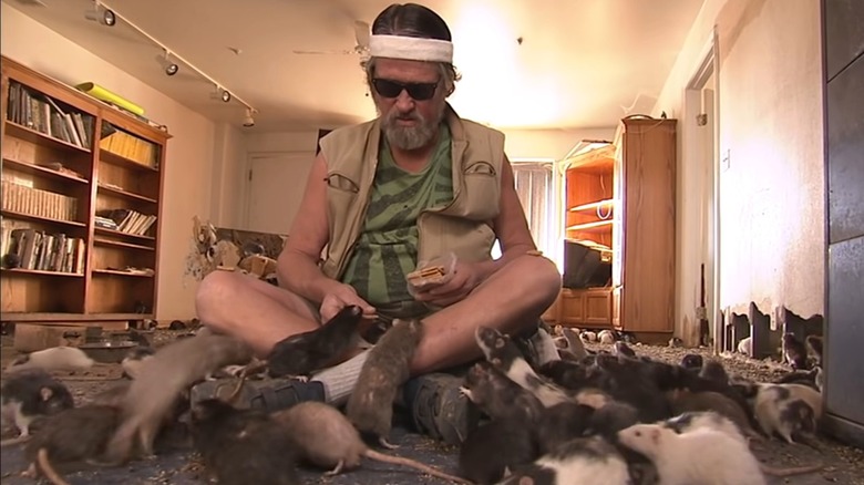 Glen Brittner sitting on floor surrounded by rats
