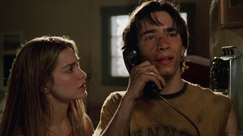 Darry covered in dirt on the phone with Trish looking at him worried