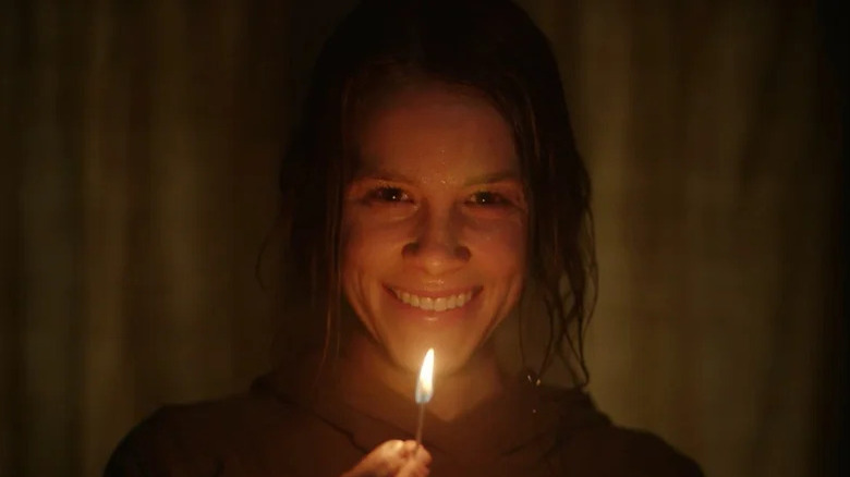 Rose smiling while holding a match