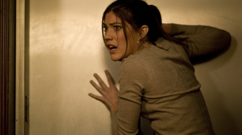 A frightened Angela leans against a wall in "Quarantine" (2008)