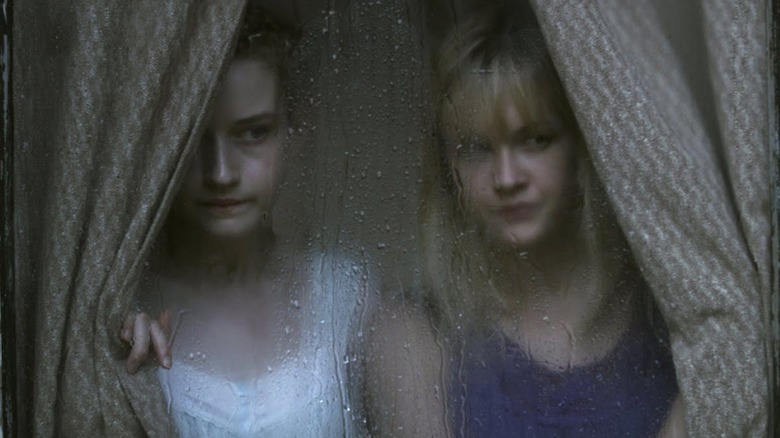 Rose and Iris Parker peer through a rain-streaked window in "We Are What We Are" (2013)