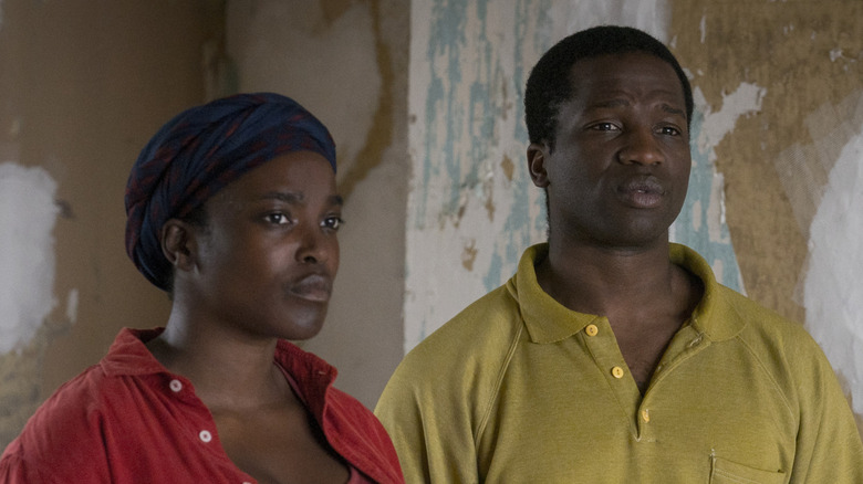 Rial and Bol standing in their rundown house