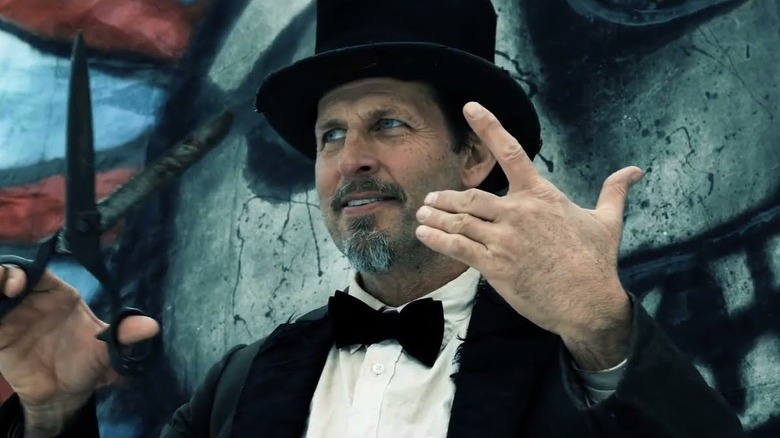 Seven prepares to cut off a finger in Where the Devil Roams (2023)