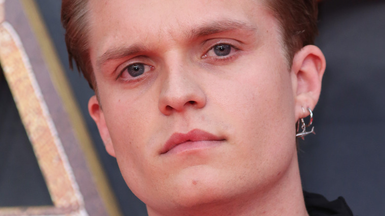 Tom Glynn-Carney wearing a shark earring