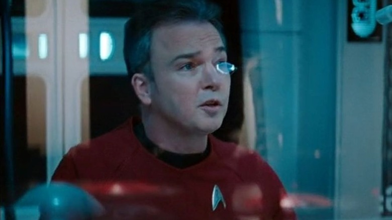 A transport officer in a red uniform sits in the transport room in Star Trek Into Darkness (2013)