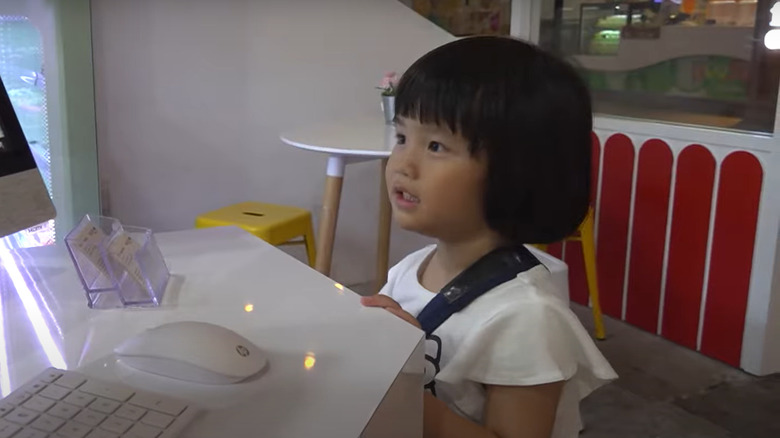 Child paying for goods in Old Enough 