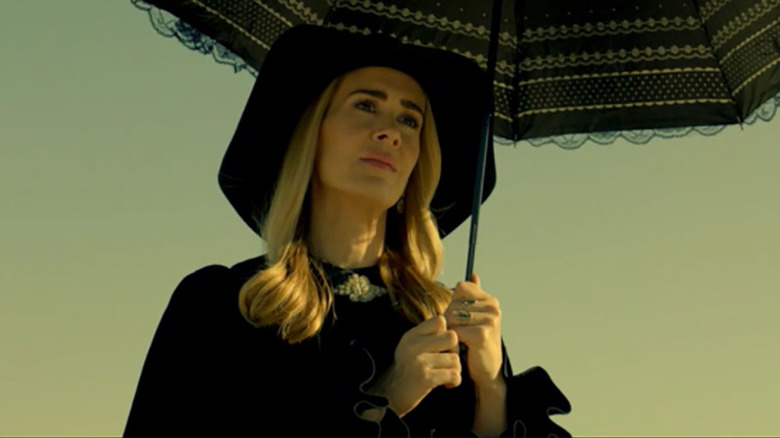 Coven character holding black umbrella