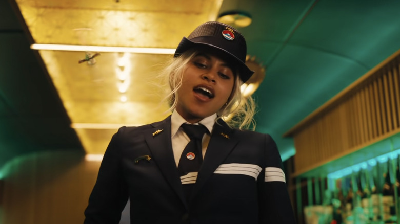 Blonde Zazie Beetz wearing a train attendant uniform