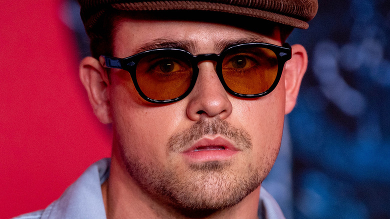 Dacre Montgomery wearing a hat and glasses