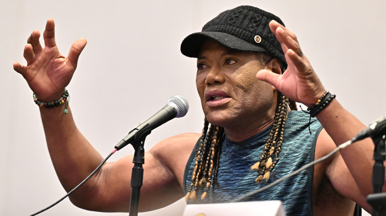 Christopher Judge gesturing as he speaks into a microphone