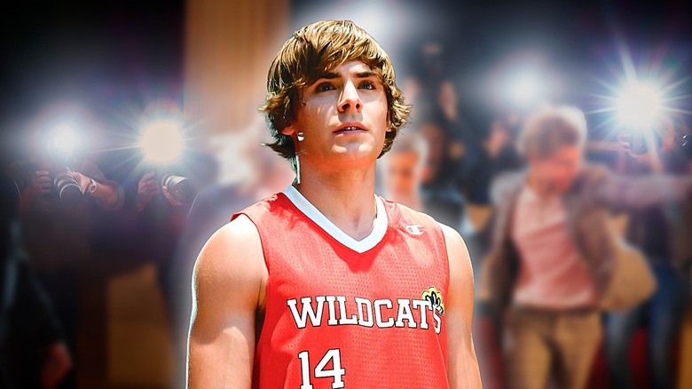 Troy Bolton standing in front paparazzi 