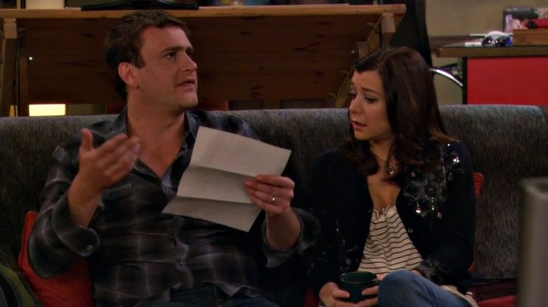 Marshall and Lily reading a document on the couch on How I Met Your Mother