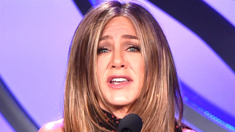 Jennifer Aniston holds a microphone