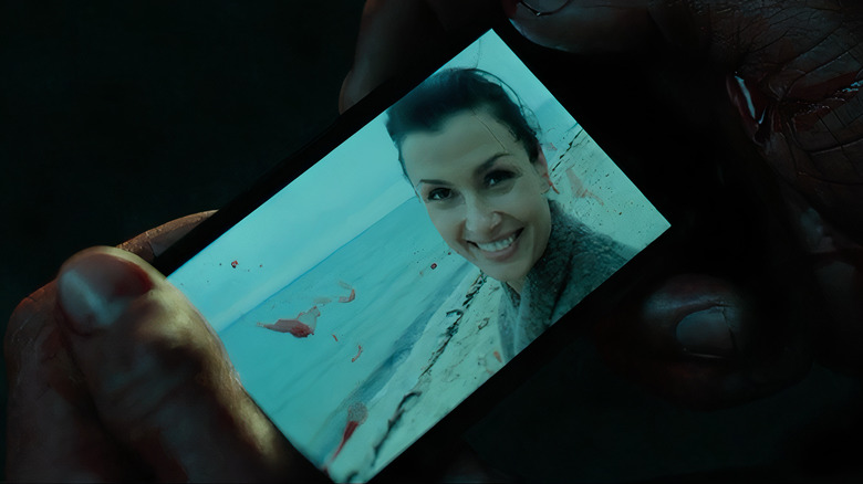 John Wick watching video of Helen Wick on bloodstained phone