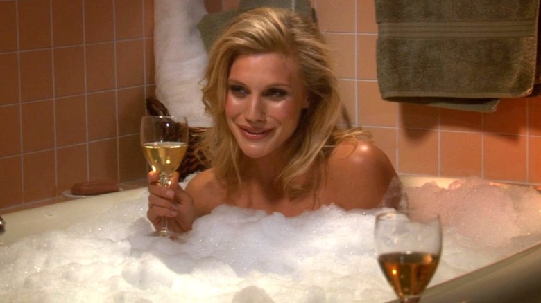 Katee Sackhoff sits in a bathtub while holding a wine glass in The Big Bang Theory (2009)
