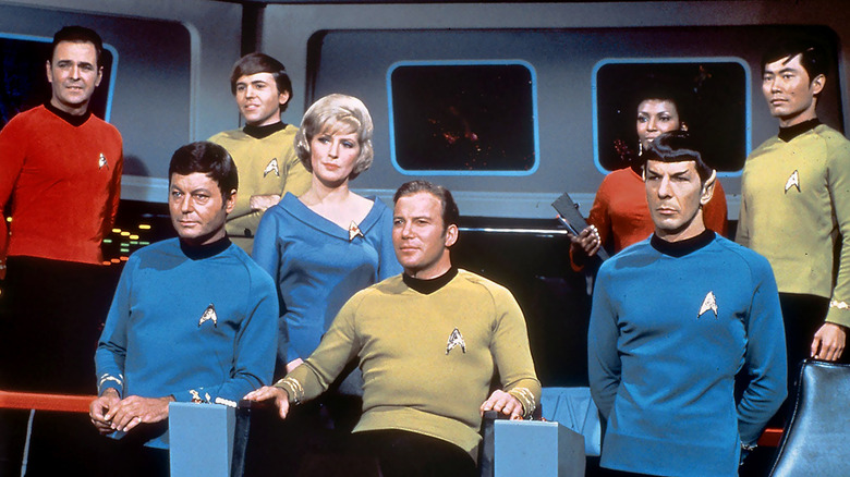 Captain Kirk flanked by Spock, McCoy, and the rest of the bridge crew on Star Trek