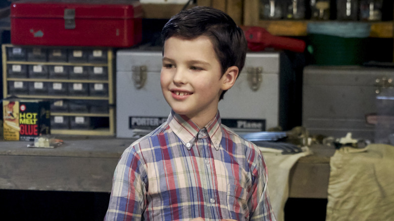 Young Sheldon playing with trains