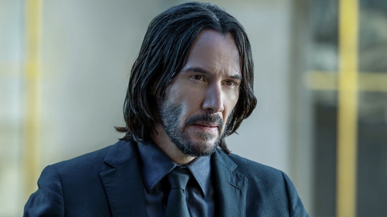 John Wick sits at a table in "John Wick: Chapter 4" (2023)