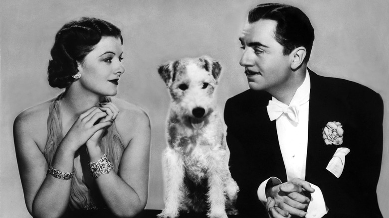 Myrna Loy and William Powell as Nick and Nora Charles pose for a photo with Asta 