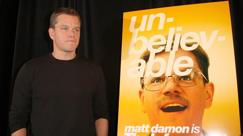 Matt Damon standing beside a poster for "The Informant!"